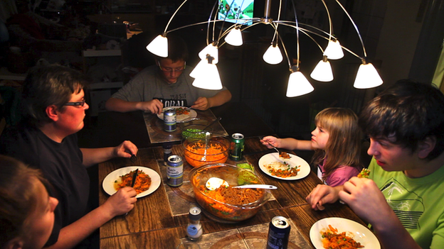 Family sitting round the table eating dinner