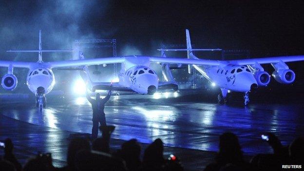 Virgin Galactic's SpaceShipTwo (C), which is carried by a twin-hulled aircraft named Eve, is unveiled in Mojave, California in this 7 December 2009