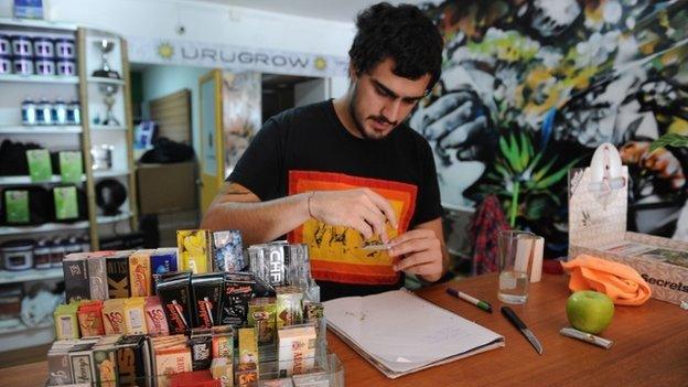 Juan Manuel, owner of the first shop dedicated to cannabis merchandising in Montevideo, rolls a joint on April 24, 2014.