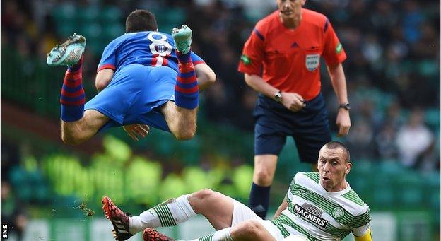 Inverness midfielder Ross Draper is sent flying in a challenge with Celtic captain Scott Brown