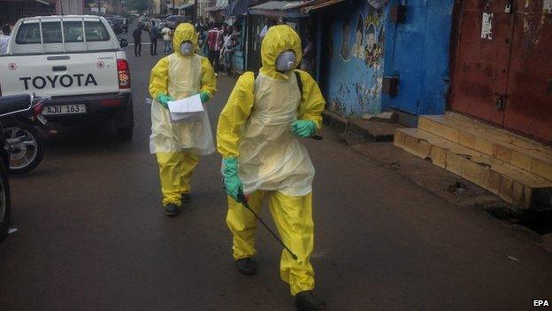 Sierra Leone health workers walk in central Freetown, Sierra Leone on 24 October 2014