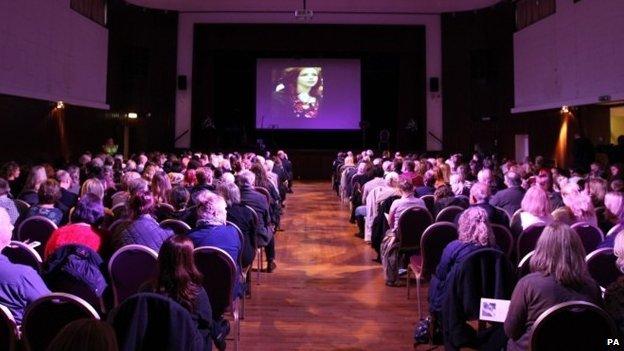 Images of Alice Gross are shown during a public memorial service