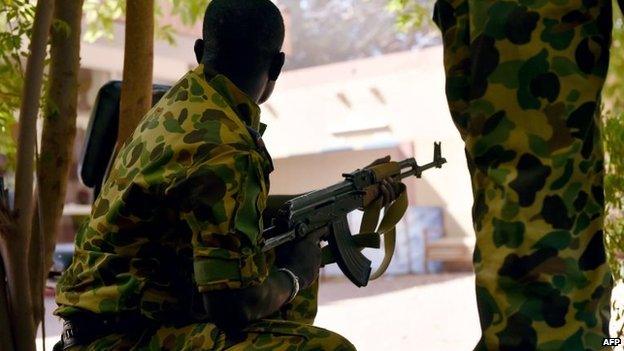 A Burkinese soldier takes position in the courtyard of the national television headquarters after shots were fired around the premises in Ouagadougou, 2 November 2014