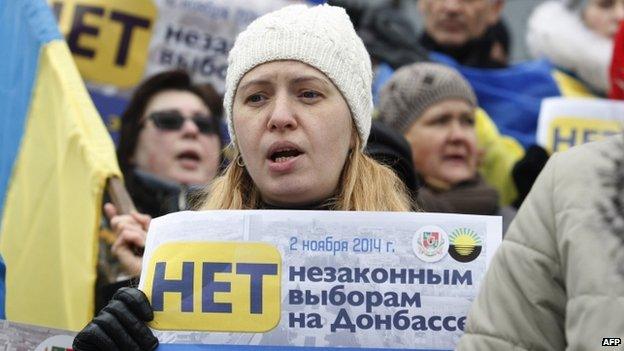 A woman in Kiev holds placard "Donbas is Ukraine! No illegal voting in Donbas!"