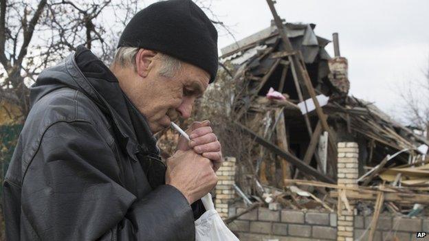 A man smokes next to a destroyed house near Donetsk. Photo: 2 November 2014