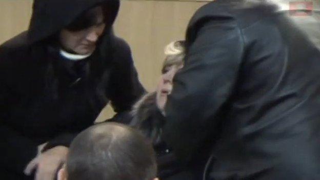 The "defendant's" mother is restrained after sentence is passed