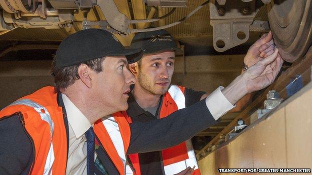 George Osborne checking tram wheels with a workman