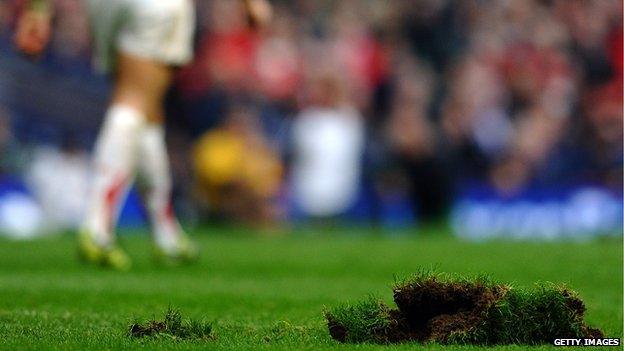 A Wales player walks past a piece of turf during a match against Australia in 2010