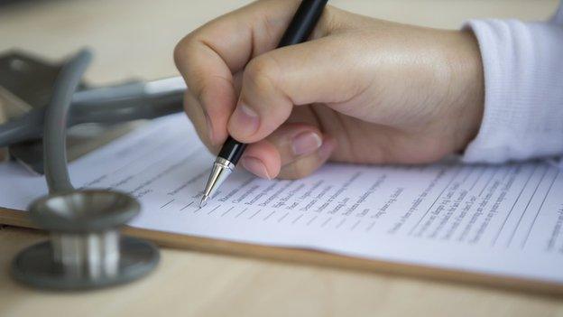 doctor writing on prescription