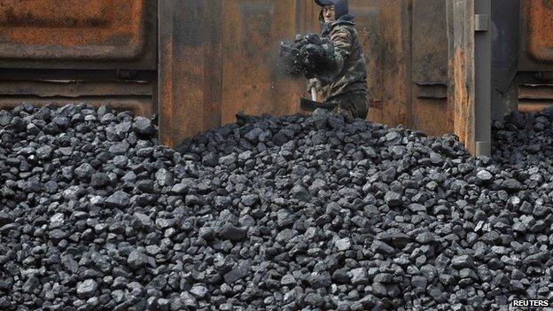 Worker unloading coal from railway in Shenyang, China, file photo from 2010