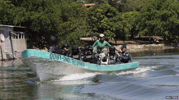 Federal police on a boat search a river for 43 missing student teachers on 30 October, 2014.