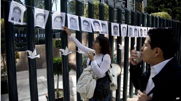 Students read aloud the names of the missing 43 rural college students, whose images were strung on the front gate of the Mexican attorney general's office in Mexico City on 29 October, 2014