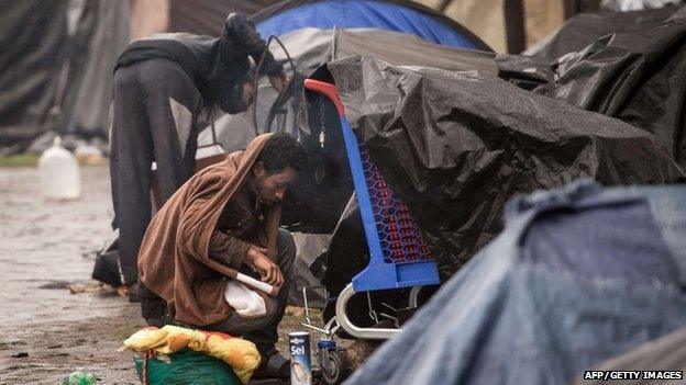 An illegal migrant sits on October 29, 2014 near makeshift tents in the northeastern French port of Calais