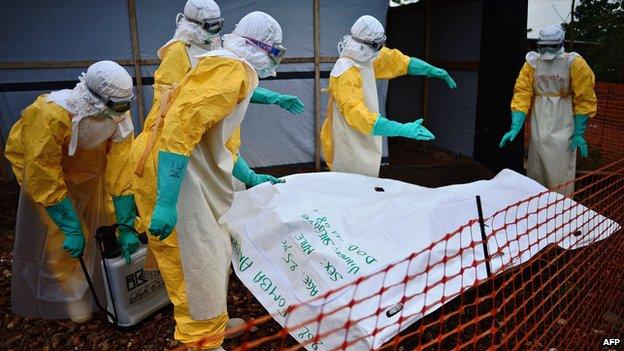 Health workers from Medecins Sans Frontieres disinfect body bag in Sierra Leone, August 2014