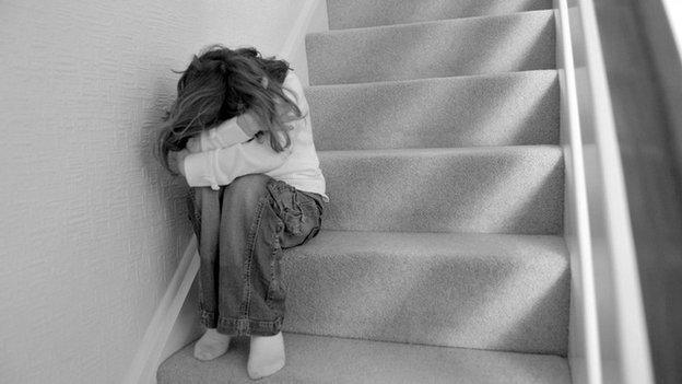 child with head in hands on stairs