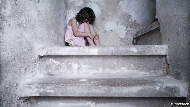 child curled up in a ball on stairs