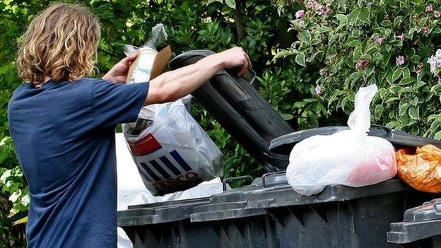 Person putting rubbish in a bin