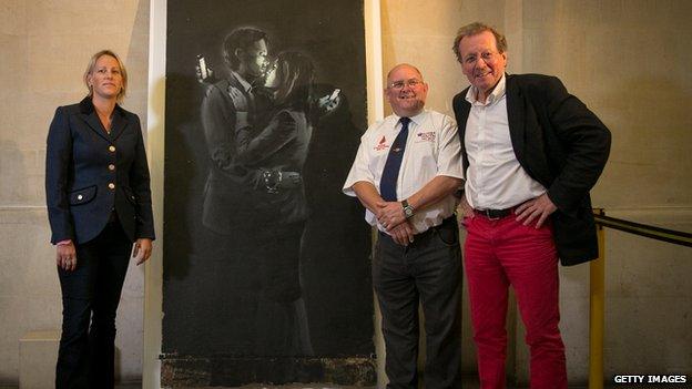 Bristol Mayor George Ferguson poses for a photograph in front of Banksy's mural 'Mobile Lovers'