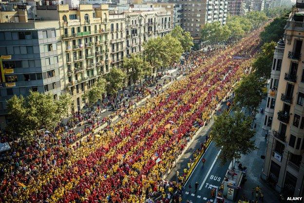 Tens of thousands of Catalans in red and yellow shirts waving independence flags (Esteladas) gather in Barcelona's Gran Via on Catalonia's national day to form a giant 'V'