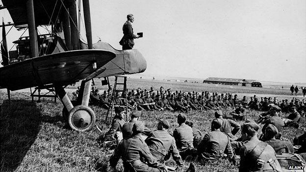 An army chaplain conducts a service from the cockpit of an aeroplane