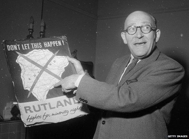 Sir Kenneth Ruddle, chairman of Rutland County Council, holds up a poster condemning the governments plans to incorporate the ancient county of Rutland into neighbouring Leicestershire