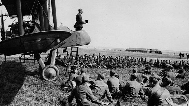 An army chaplain conducts a service from the cockpit of an aeroplane