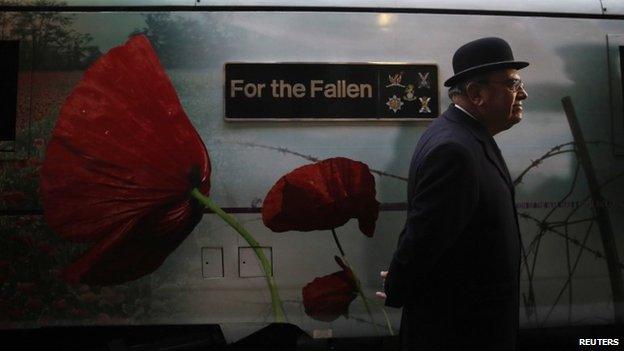 Man walks past a train with commemorative wrap for the fallen of World War One
