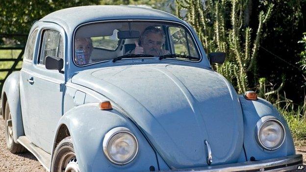 President Jose Mujica flashes a thumbs up as he and his wife, Sen. Lucia Topolansky, ride away from their home on the outskirts of Montevideo - 2 May 2014