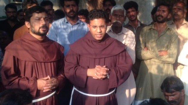 Monks and the grieving families of Sajjad and Shama Mesih pray in Pakistan on November 2014