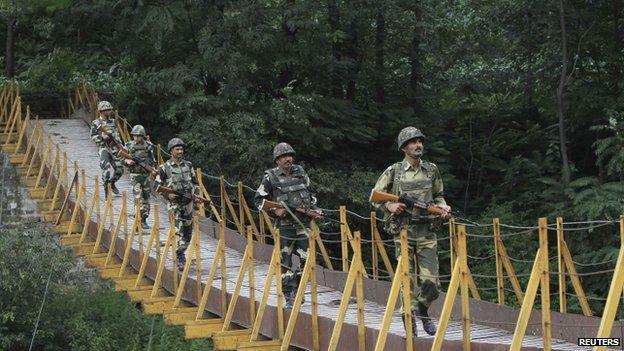 Indian Border Security Force (BSF) soldiers patrol over a footbridge near the Line of Control that divides Kashmir between India and Pakistan