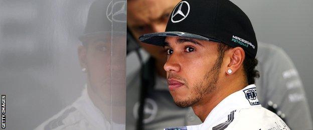 Lewis Hamilton of Great Britain and Mercedes GP looks on in the garage during qualifying for the Brazilian Formula One Grand Prix.