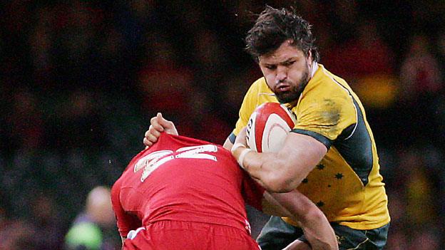 Adam Ashley Cooper of Australia is tackled by a Wales defender