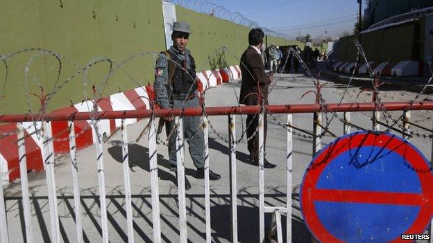 A policeman keeps watch at the gates of the police headquarters in Kabul (9 November 2014)