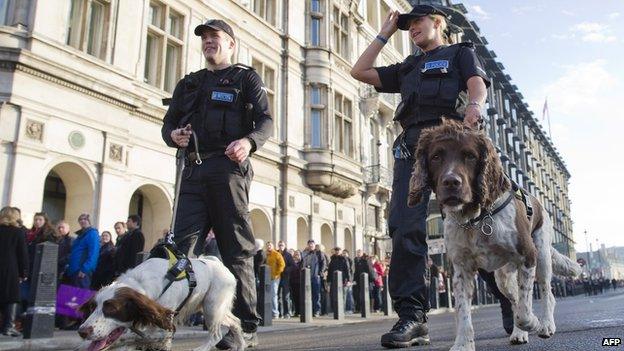 Police patrol with sniffer dogs outside the Houses of Parliament near to the venue of the Remembrance Sunday service in central London