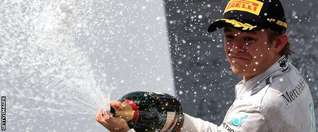 Nico Rosberg celebrates his victory by spraying champagne