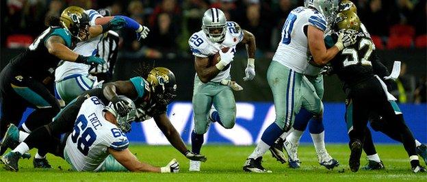 DeMarco Murray bursts through a hole in the Jacksonville defence