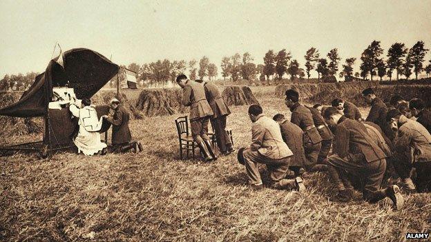 Belgian chaplain conducts a service in a field