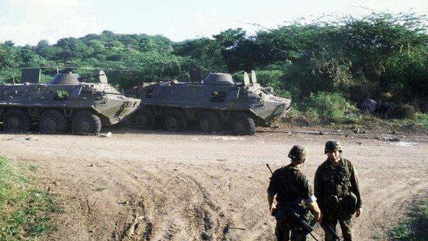 US soldiers stand next two armoured personnel vehicles as they patrol near St George's, the capital of the Grenada, October 1983