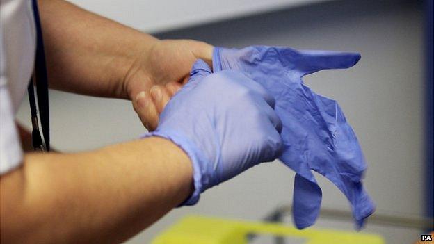 Nurse putting on gloves