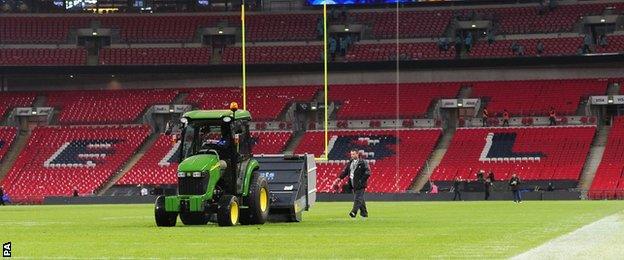 Ground staff work on Wembley pitch