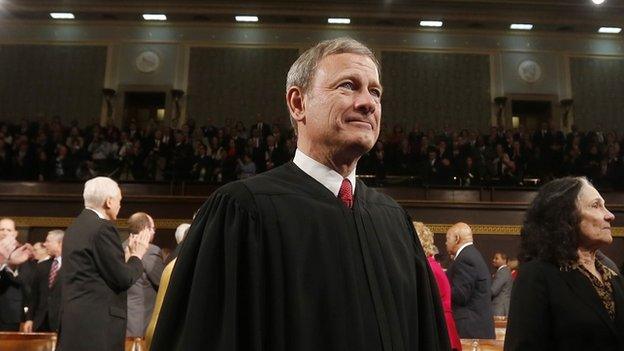 Supreme Court Chief Justice John Roberts stands at the 2014 State of the Union address.