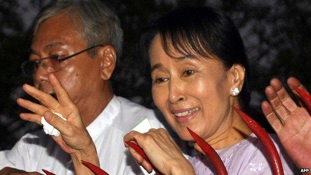 Aung San Suu Kyi waves to a crowd of supporters gathered outside her house after her release in Yangon on 13 November 2010