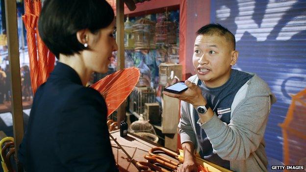 Man talking to a woman via his Google translate phone