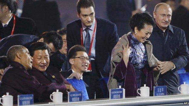 In this Nov. 10, 2014 file photo, Russia"s President Vladimir Putin, right, puts a shawl on Peng Liyuan, second right, wife of Chinese President Xi Jinping,