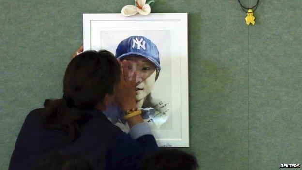 A relative with the portrait of a lost loved one, in the town of Jindo, 11 Nov