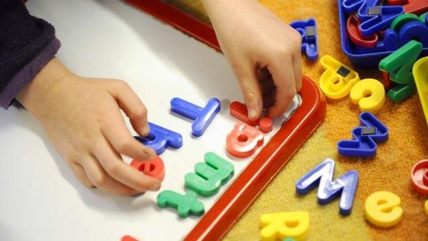 Primary school child plays with plastic letters