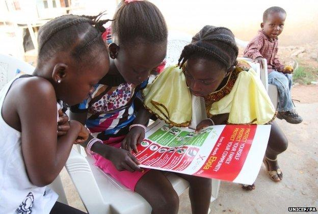People in Lofa county looking at a poster offering Ebola advice