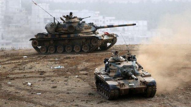 Turkish tanks manoeuvre near the Syrian border town of Kobane where Kurds are fighting Islamic State (11 Oct)