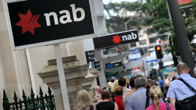 People walk past National Australia Bank signs adorning a building in central Brisbane - 5 December 2011