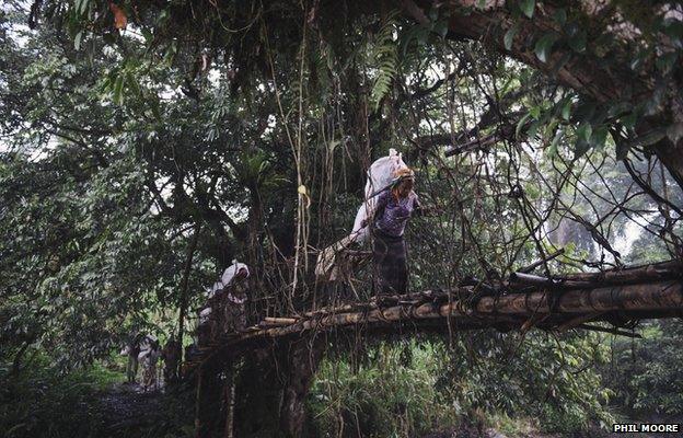 Porters carry sacks containing vaccination equipment